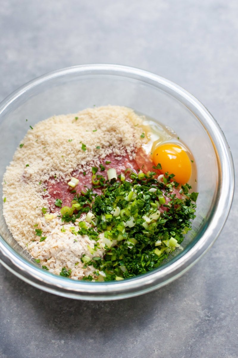 Breadcrumbs, spices, green onion, ground beef, and egg in a mixing bowl to make Garden Onion Burger patties