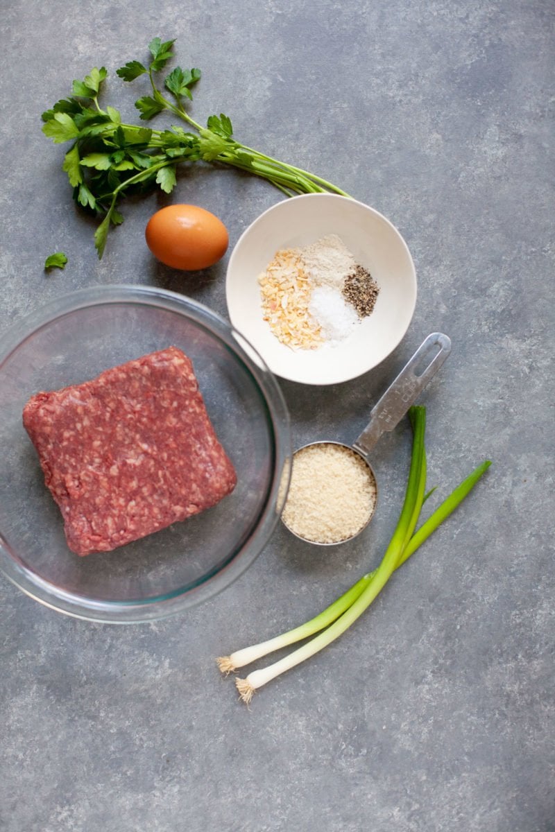 Overhead shot of ingredients for Garden Onion Burgers - beef, spices, egg, green onion, and breadcrumbs