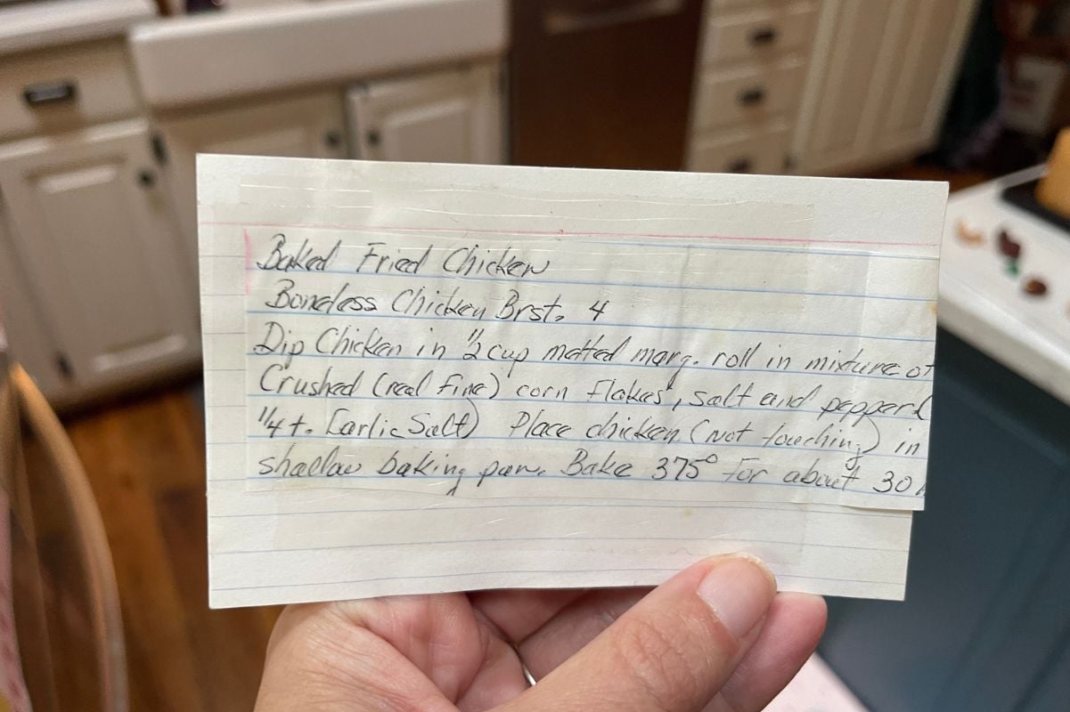 Hand holds an index card with a recipe written on it