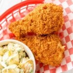 Close-up of crispy cornflake-crusted chicken drumsticks and potato salad
