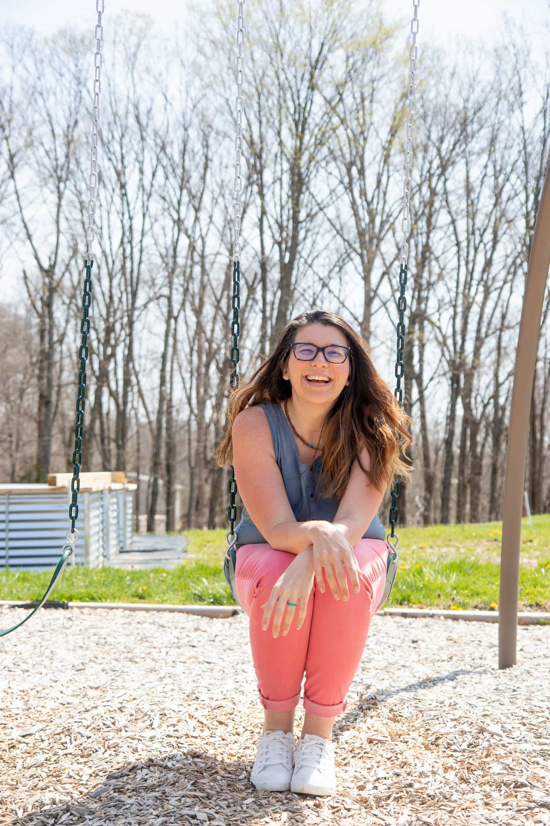 Woman sitting on a swing outside, smiling