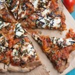 Top view of homemade pizza topped with sauce, cheese, and fresh basil.