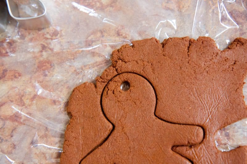 A hole poked in the head of a gingerbread person so that it can be hung as an ornament