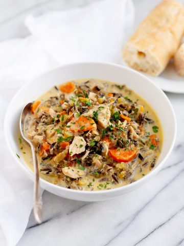 Cream of Turkey and Wild Rice Soup in a white bowl with a spoon