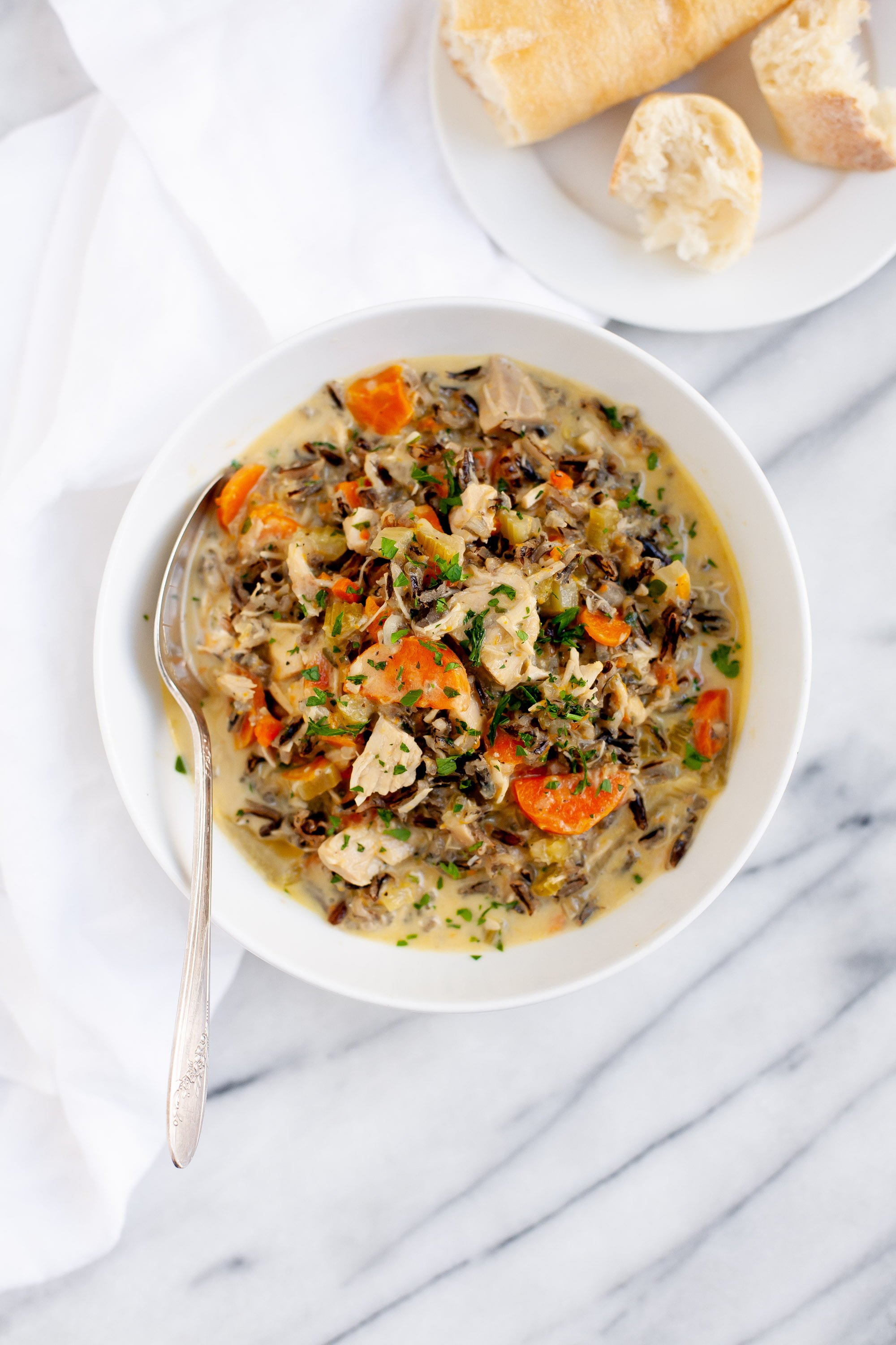 Overhead view of Cream of Turkey and Wild Rice Soup in a white bowl with a spoon