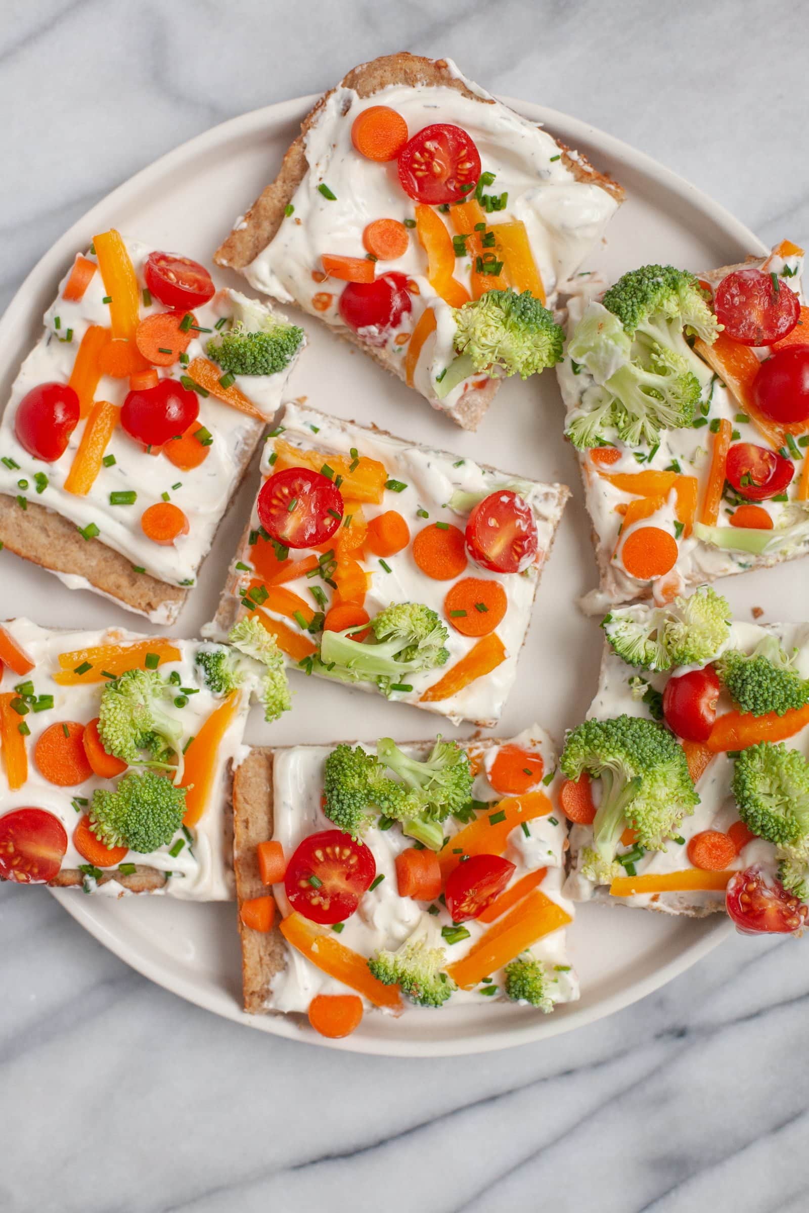Off-white plate of Cold Veggie Pizza Appetizers cut into squares