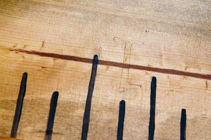 A numeral one outlined in pencil on a wooden growth chart ruler.