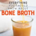 Bone broth pours out of a glass measuring cup into a glass jar on a white background. A text overlay reads "Everything you should know about bone broth"