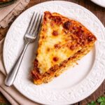 A slice of spaghetti pie on a white plate