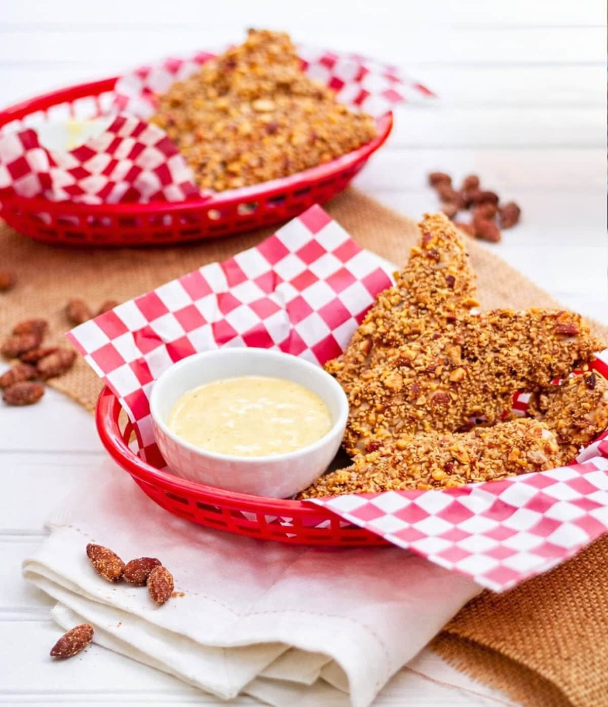 Almond breaded chicken strips in a basket on a table
