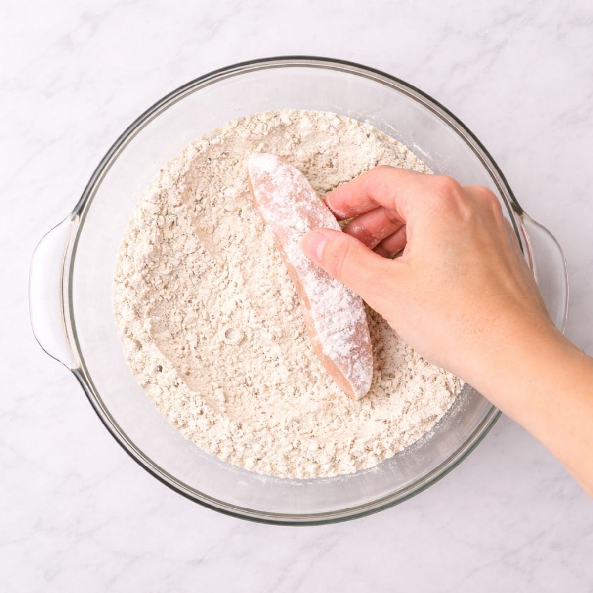 Dredging chicken strip in flour