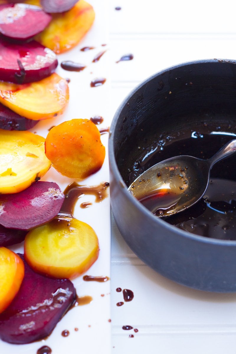 Roasted Beets sliced and arranged on a white platter, glazed with balsamic