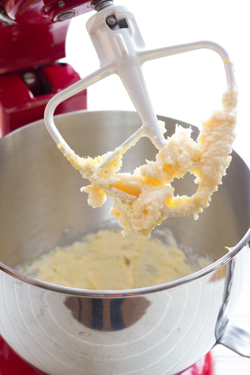 A stand mixer beater is covered in cookie dough.