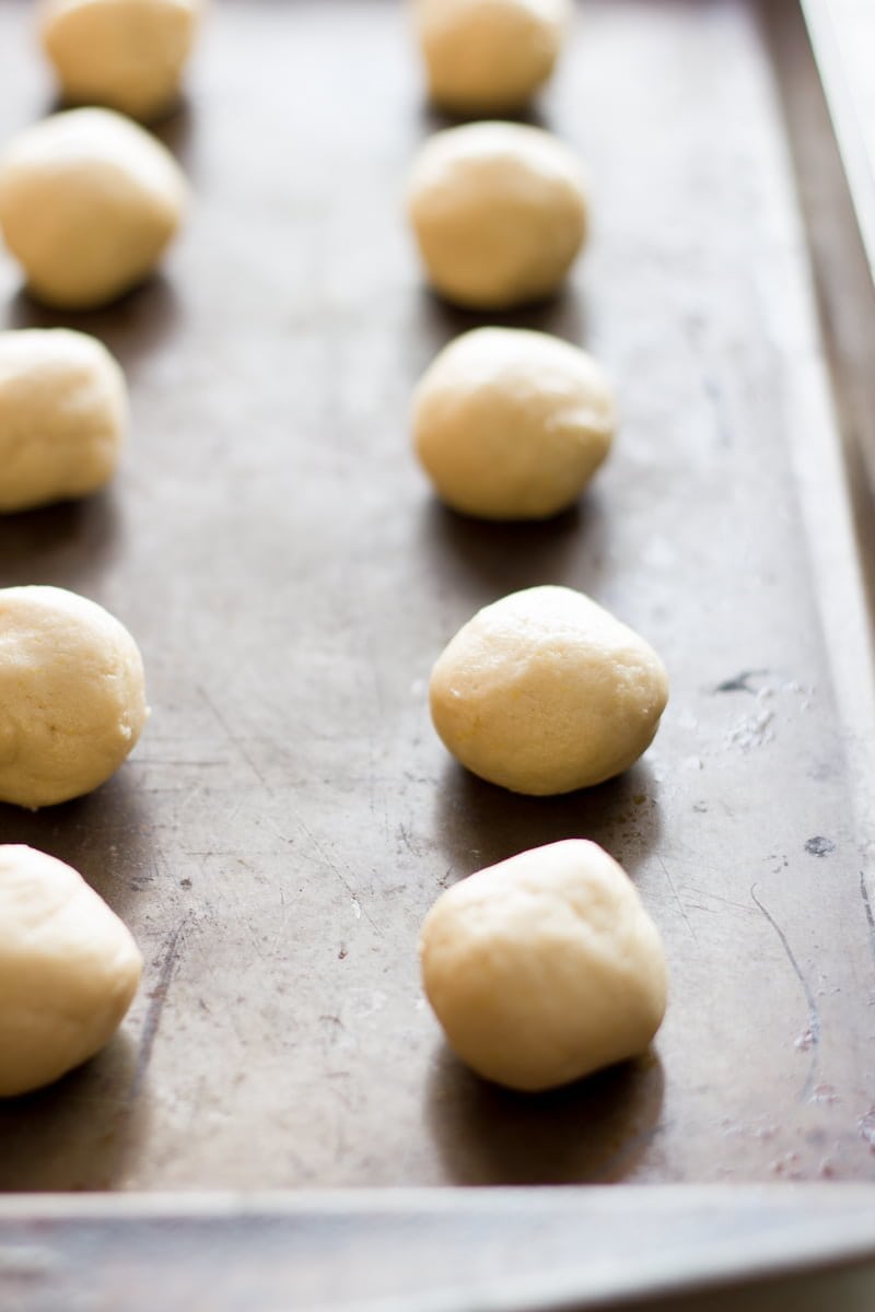 Balls of cookie dough lined up on a cookie sheet