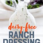 Glass bottle filled with healthy ranch dressing sits in front of a white bowl filled with salad. A text overlay reads "Dairy-Free Ranch Dressing."