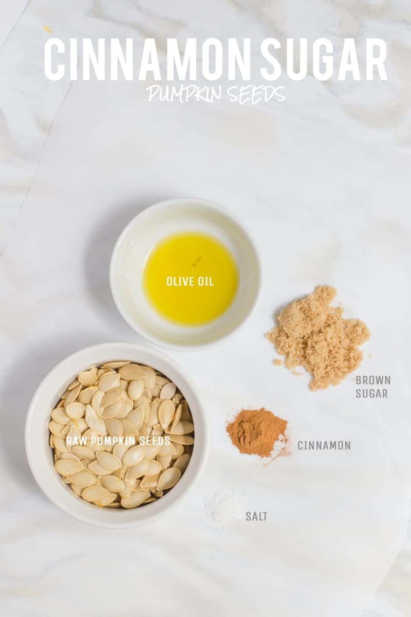 All ingredients for Cinnamon Sugar flavored roasted pumpkin seeds are laid out on a white marble countertop. 