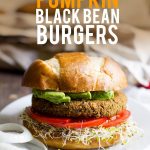 A Pumpkin Black Bean Burger sits on a white plate. A text overlay reads "vegan pumpkin black bean burgers"