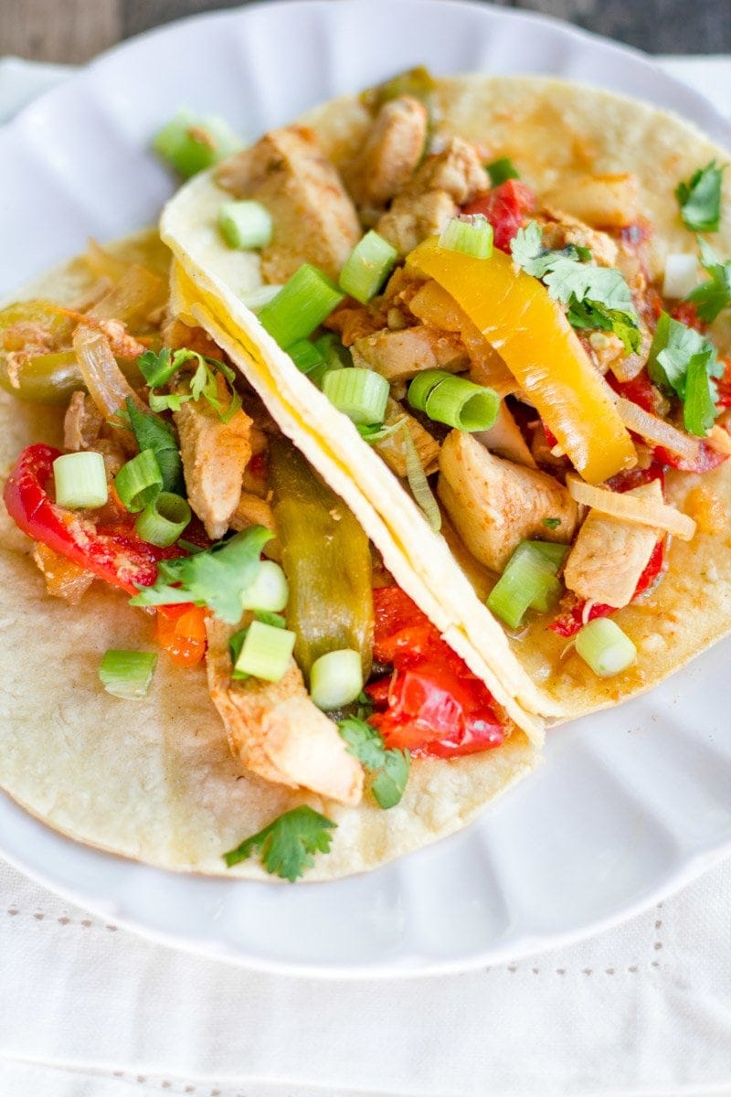 A close up shot of two Slow Cooker Chicken Fajitas on a plate.