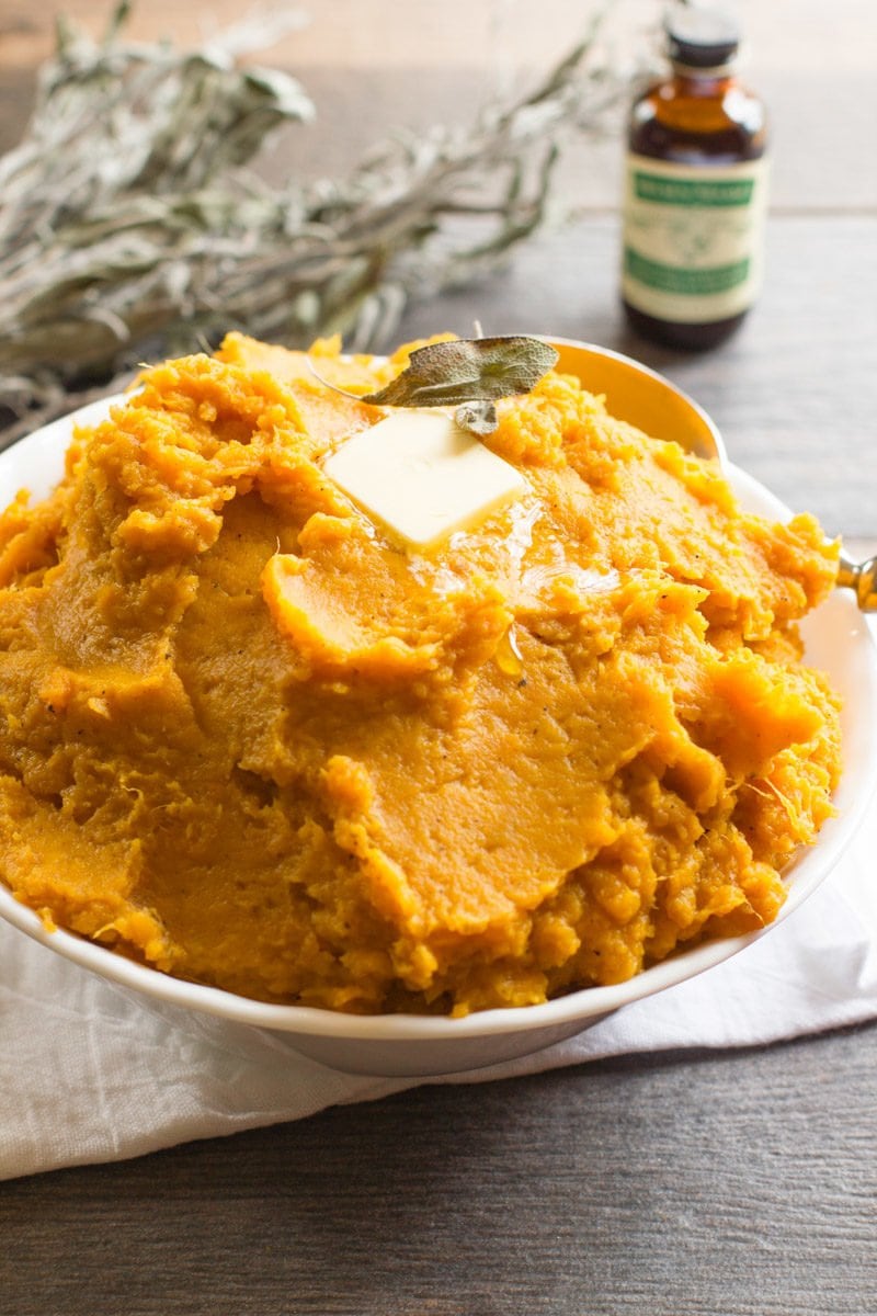 Bowl of mashed sweet potatoes topped with a pat of butter