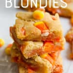 A stack of blondies studded with candy corn sits on a white background. A text overlay reads "Candy Corn Blondies."