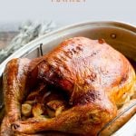 Whole Roasted Turkey in a metal roasting pan. A text overlay reads "How to Dry Brine a Thanksgiving Turkey."