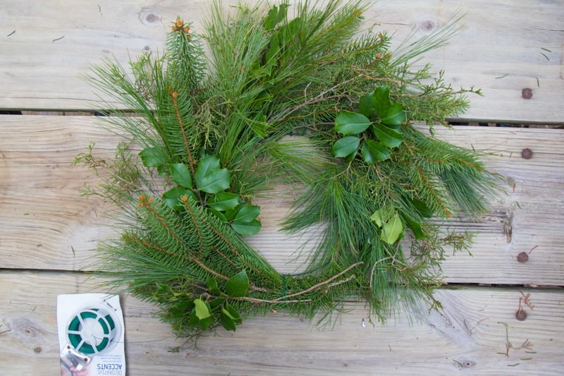 Wreath form almost completely covered in evergreens