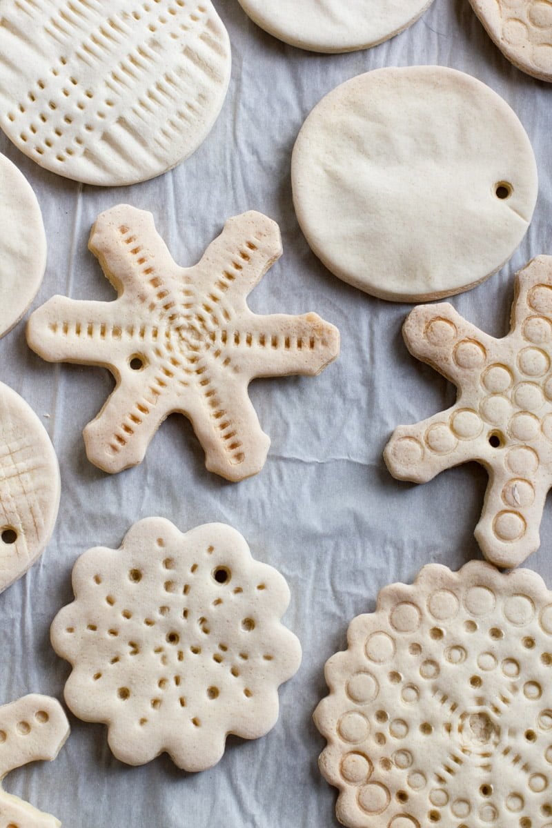 Tight view of various shapes of baked, undecorated salt dough ornaments.