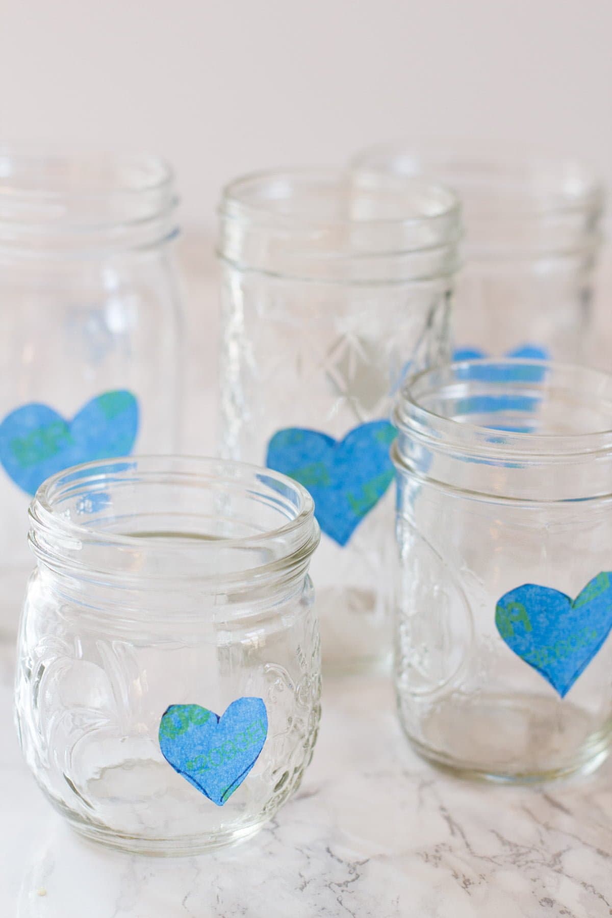 Cluster of mason jars, each with a heart made of painter's tape on the side