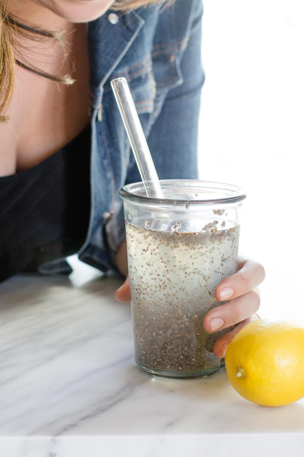 A woman leaning in to take a sip of chia seed morning elixir.