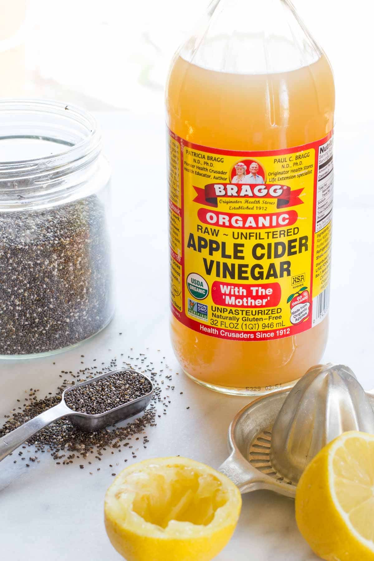 Ingredients needed to make chia seed drink including apple cider vinegar, fresh lemon juice and chia seeds.