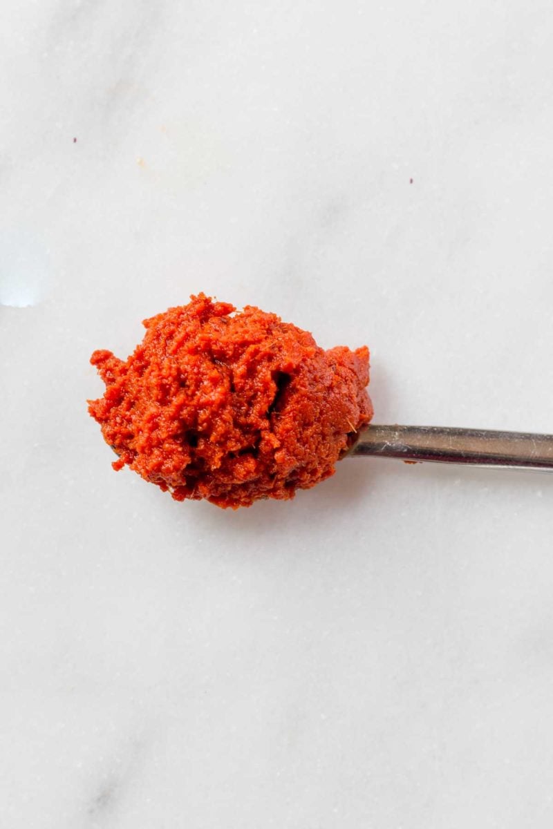 Red curry paste on a spoon, on a marbled background