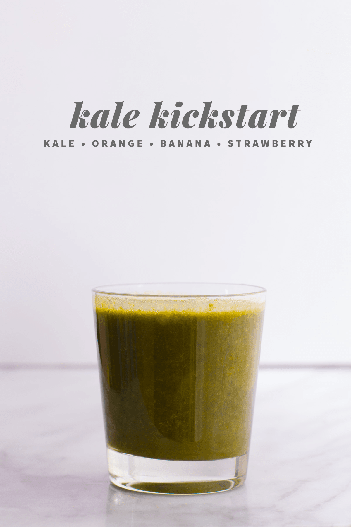 A glass of green kale kickstart smoothie, a fresh addition to juice recipes, labeled with the ingredients: kale, orange, banana, and strawberry.
