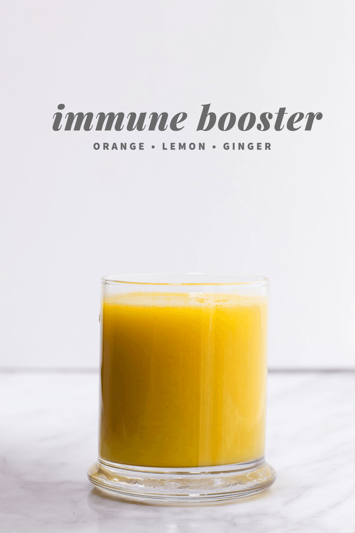 A glass of immune booster juice, one of many healthy juice recipes, containing orange, lemon, and ginger.
