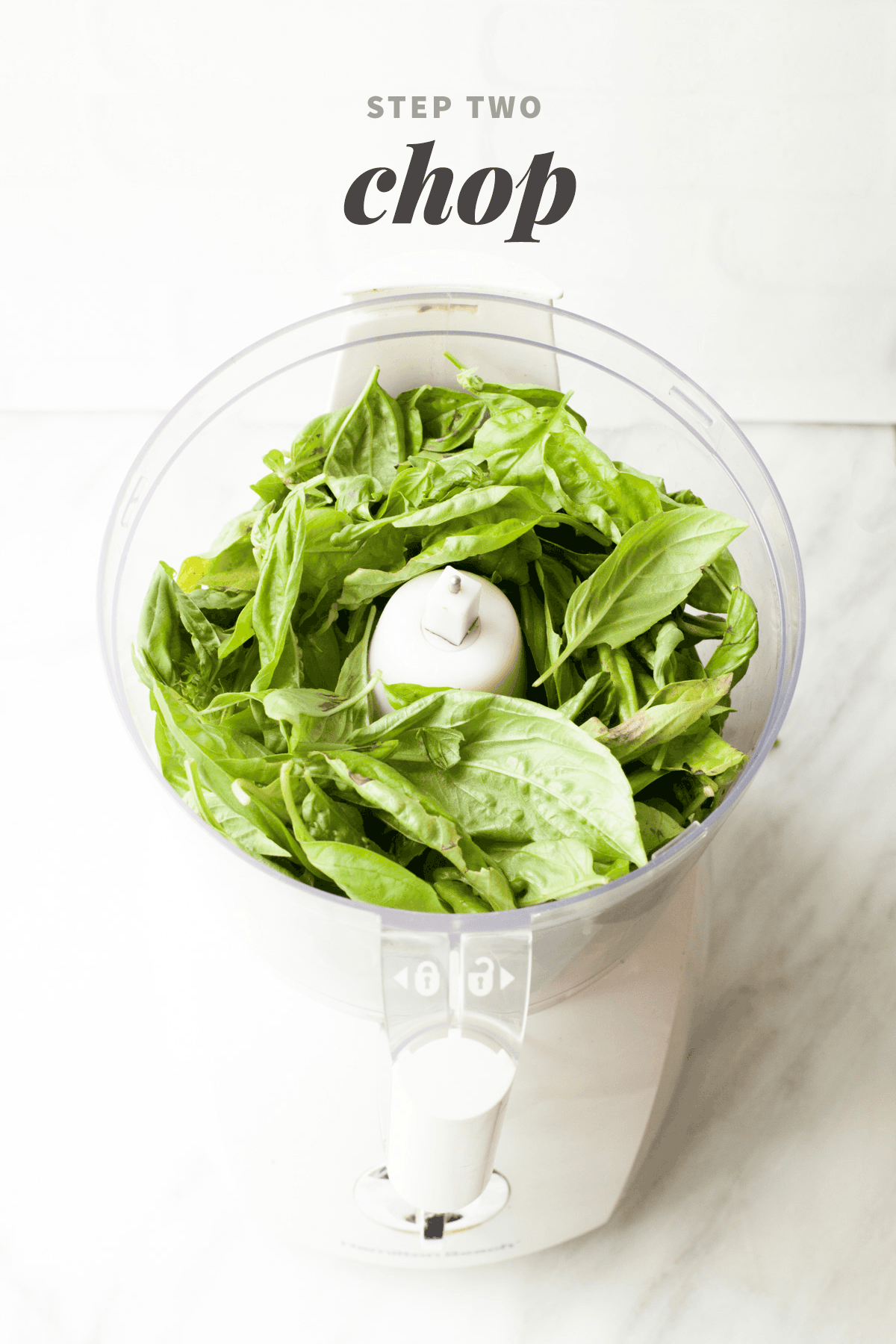 Fresh basil leaves fill a food processor bowl. A text overlay reads "Step Two: Chop."