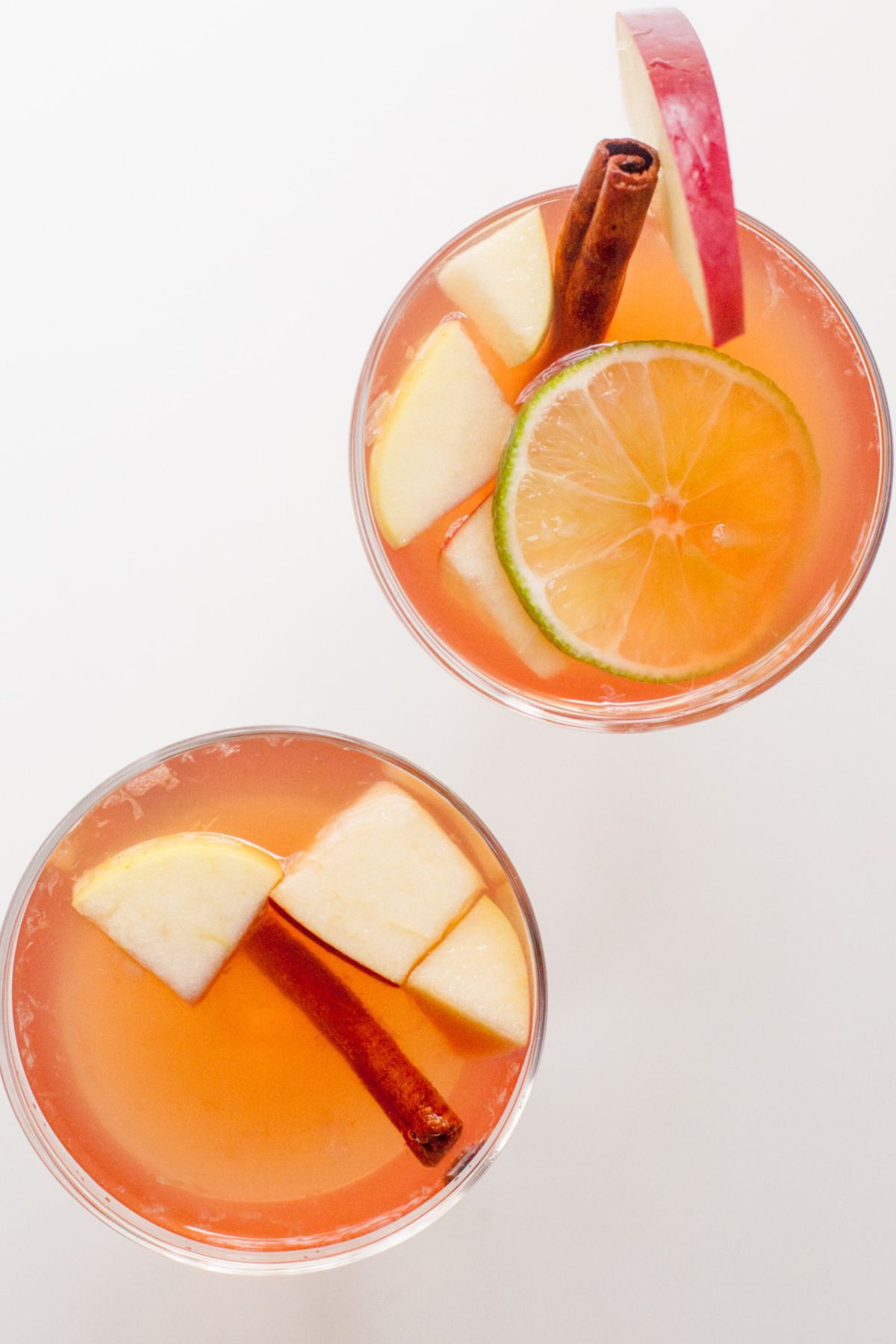 Two glasses of rose sangria sit on a white countertop.
