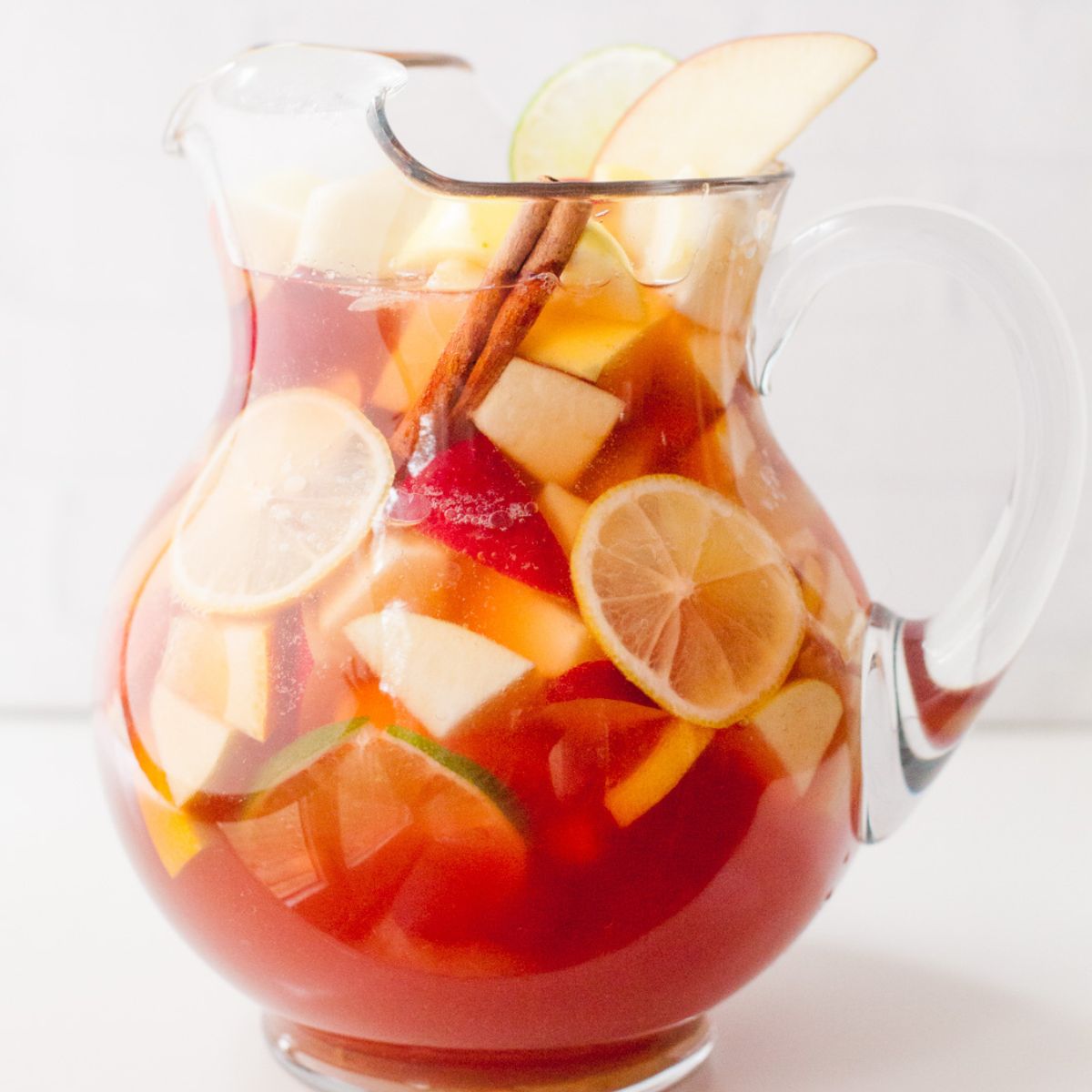 A pitcher of rose sangria sits in a white kitchen.