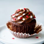 healthier chocolate cupcakes sits on a white plate.