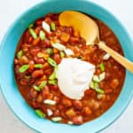 Cashew sour cream on top of chili in a blue bowl.