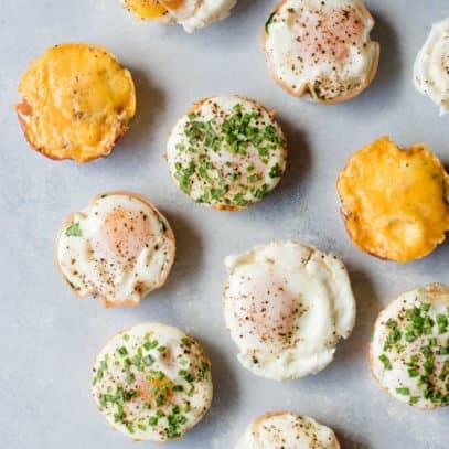 A variety of breakfast egg muffins sit on a gray background.
