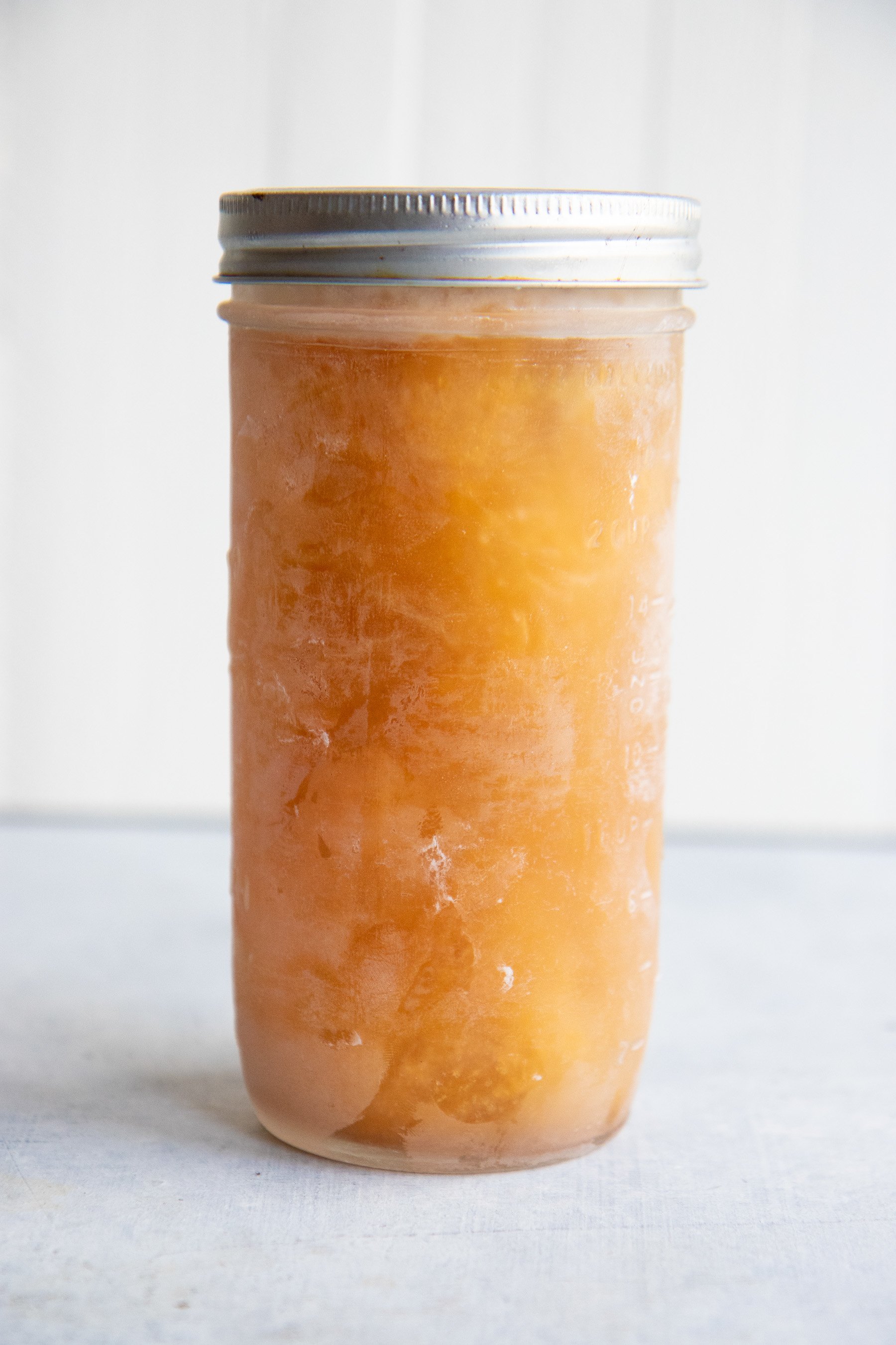 Side shot of a frozen jar of chicken bone broth