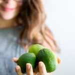 Woman holding out 3 limes in her palm