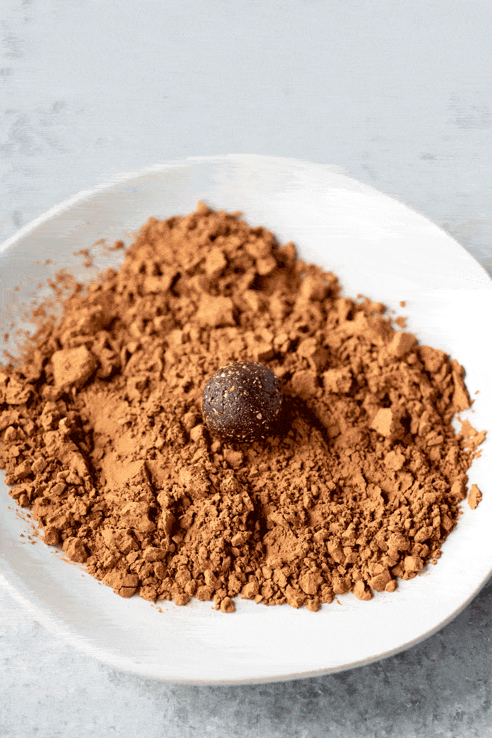 Gif of a single Ginger Bite (an all-natural upset stomach remedy) being rolled in cocoa powder