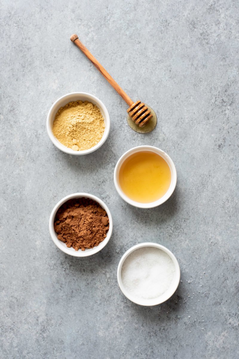 Overhead shot of ingredients for Ginger Bites (an all-natural upset stomach remedy) on a gray surface