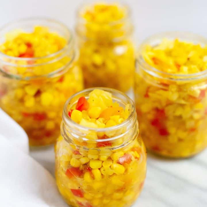 Side angle shot of Homestyle Corn Relish in glass mason jars, ready for canning
