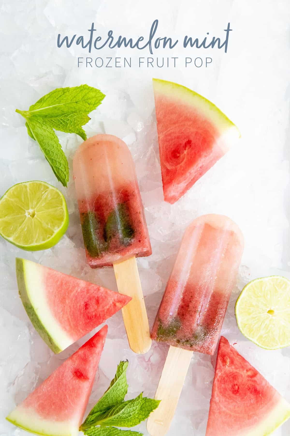 Watermelon Mint Frozen Fruit Pops on a bed of crushed ice, surrounded by watermelon wedges, mint sprigs, and half a lime