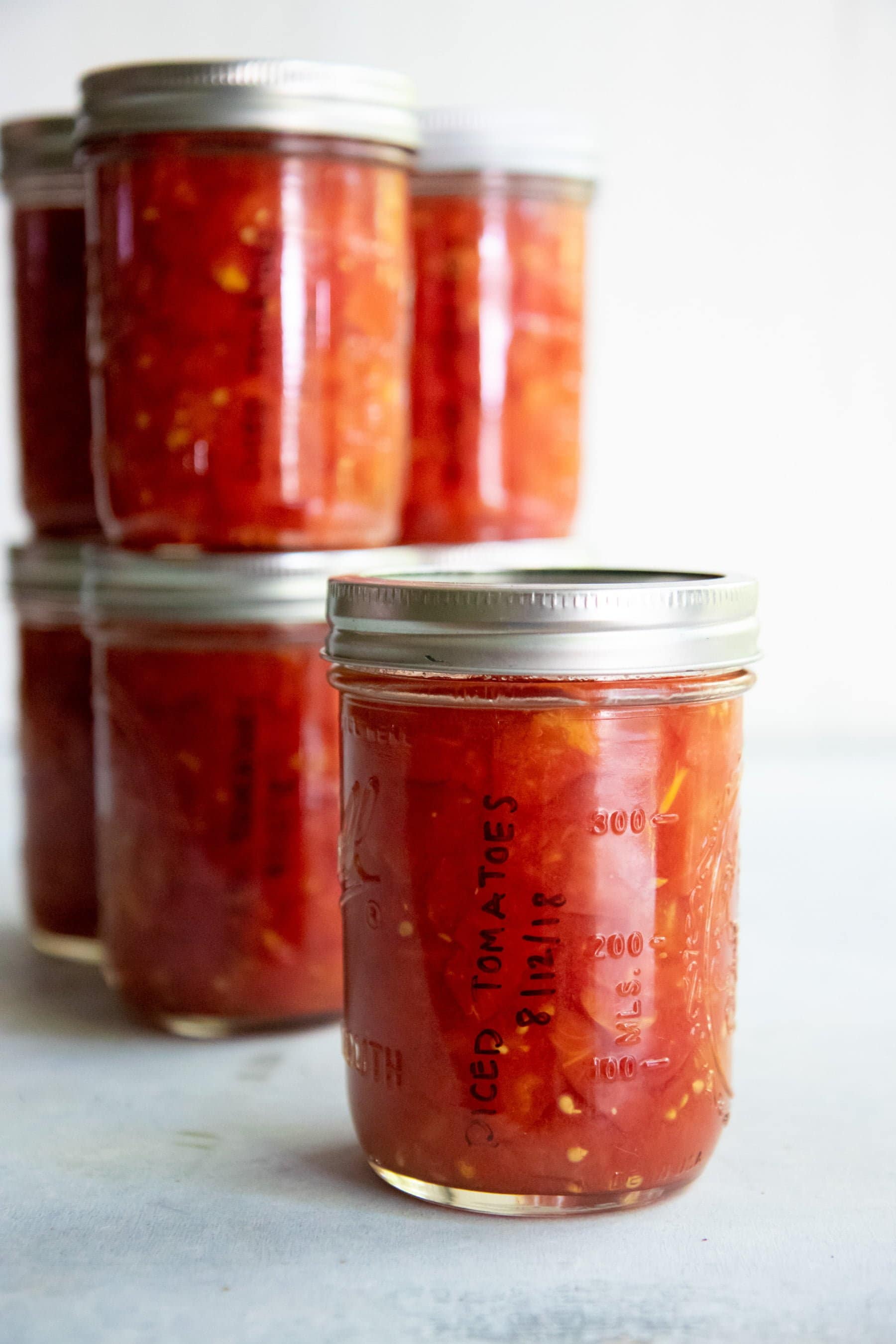 Glass jars filled with canned diced tomatoes