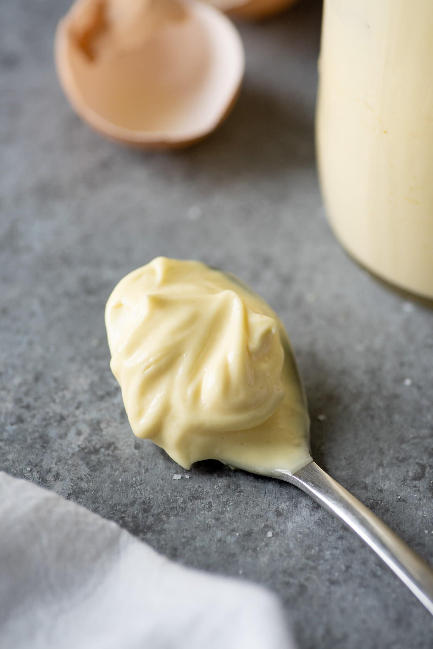 Spoon full of Homemade Mayo on a grey background