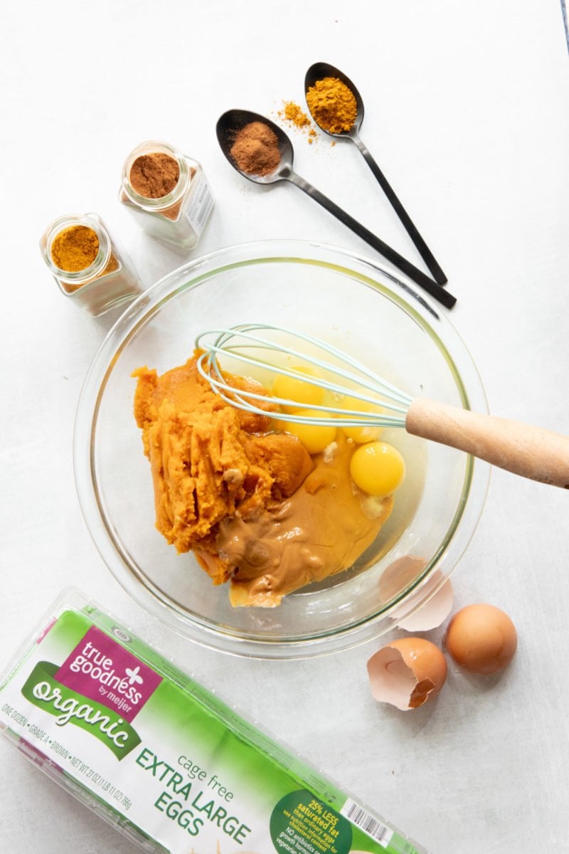 Ingredients for Grain-Free Pumpkin Coconut Dog Treats being mixed together in a glass bowl