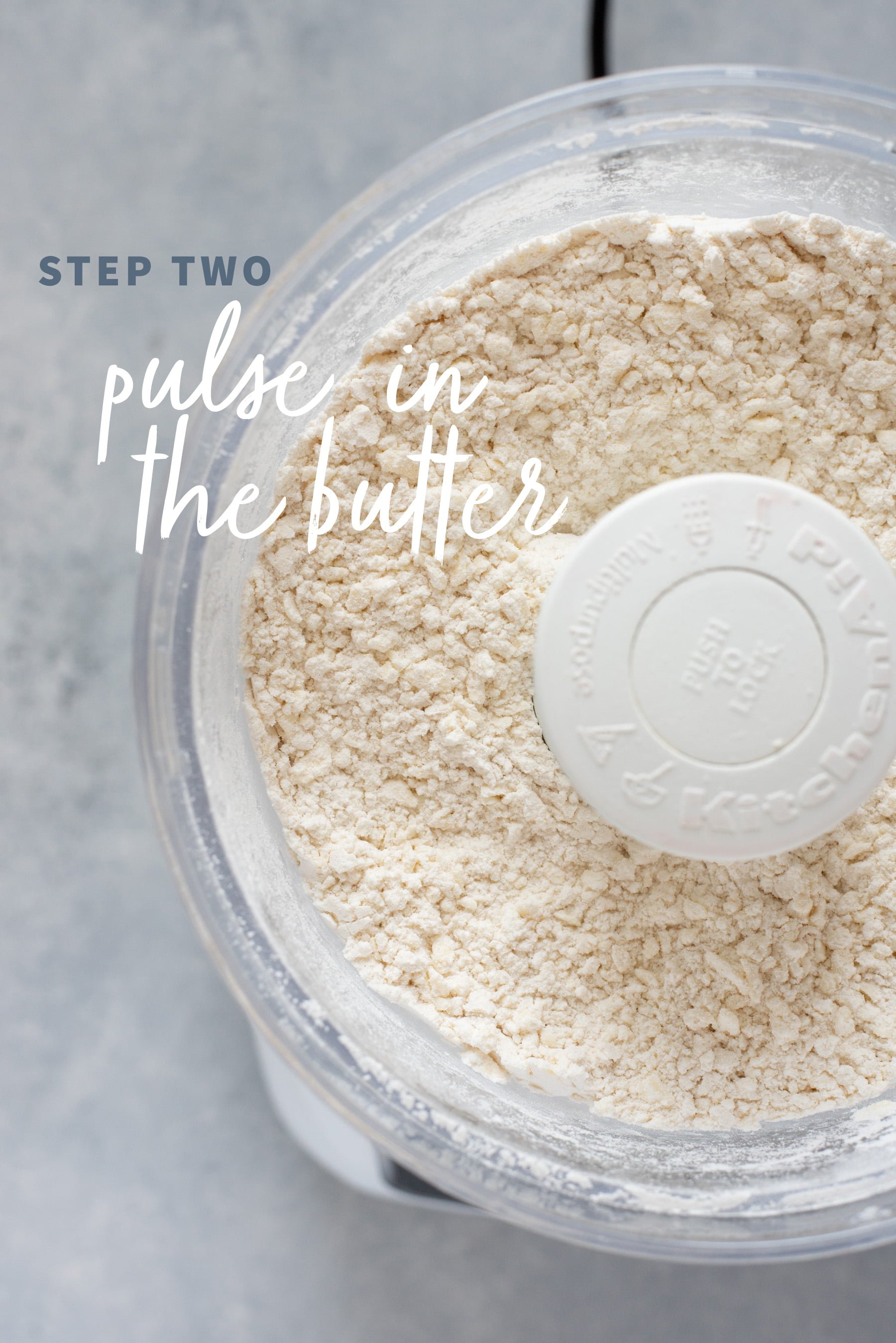 Pulsing butter into the dry ingredients for pie crust dough in the bowl of a food processor
