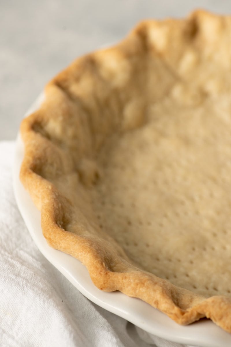 Baked pie crust with fluted edges pressed into a pie pan